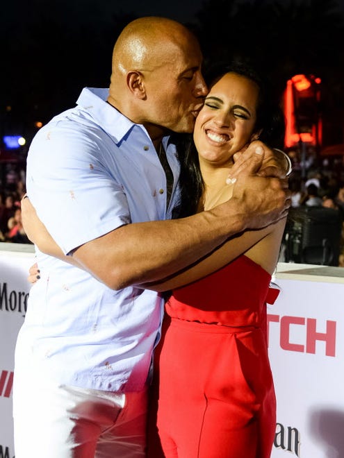 Daddy loves you! Dwayne Johnson plants a kiss on his daughter Simone Johnson.