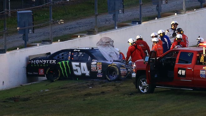 Medical crews attend to Busch after crashing during the Xfinity Series race at Daytona International Speedway on Feb. 21, 2015. Busch suffered a broken leg in the wreck and missed several weeks of the 2015 season.