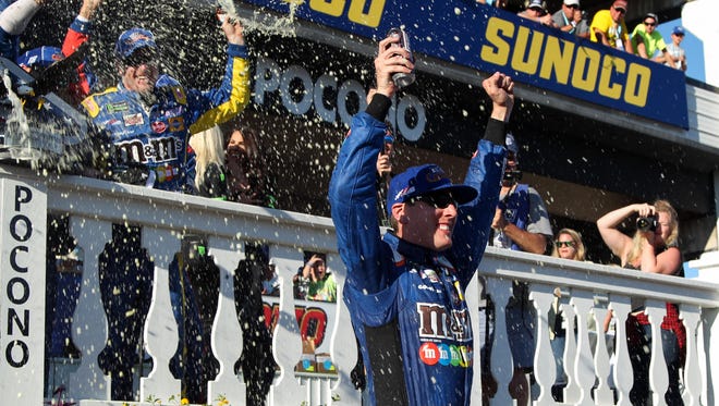 Kyle Busch celebrates in victory lane after winning the Overton's 400 at Pocono Raceway.