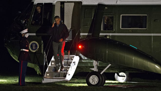 Obama salutes as he walks off Marine One on the South Lawn of the White House on Nov. 21, 2016, as he returned from his final trip to Europe as U.S. president.