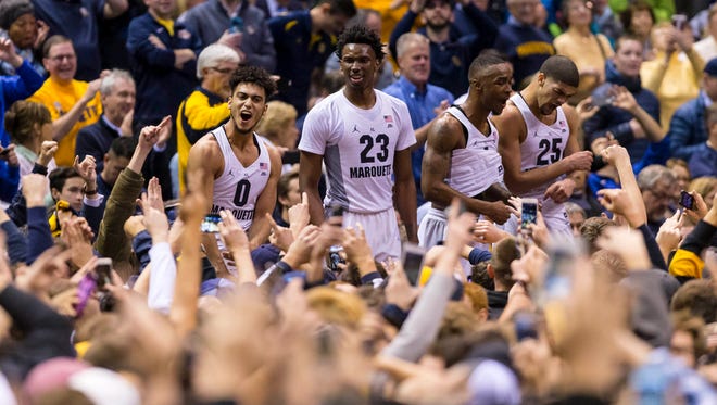 Golden Eagles players celebrate with fans after defeating Villanova.