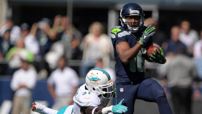 Seattle Seahawks wide receiver Tyler Lockett (16) is pursued by Miami Dolphins free safety Michael Thomas (31) during a NFL game at CenturyLink Field.