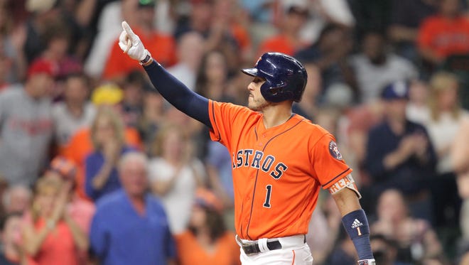 Astros shortstop Carlos Correa salutes the fans after hitting a solo home.