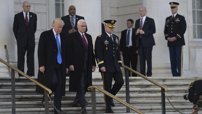 President-elect Trump (L) and Vice President-elect  Pence take part in a wreath-laying ceremony at Arlington National Cemetery.