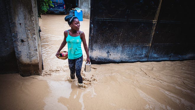 A girl walks through floodwaters that have come down from the mountains outside Port-au-Prince on Oct. 5, 2016.