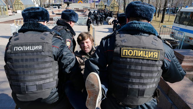 Police detain a protester in Moscow. The protests Sunday focused on reports by Navalny's group claiming that Prime Minister Dmitry Medvedev has amassed a collection of mansions, yachts and vineyards.