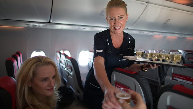 Cabin crew member Anna Ronnow serves champagne to passengers aboard Norwegian Air's Boeing 737 MAX 8 delivery flight, en route to Oslo, Norway, on June 29, 2017.