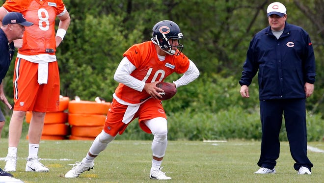 Chicago Bears quarterback Mitchell Trubisky (10) looks to pass as quarterback Mike Glennon (8) and offensive coordinator Dowell Loggains, right, watch during NFL football practice Tuesday, May 23, 2017, in Lake Forest, Ill.