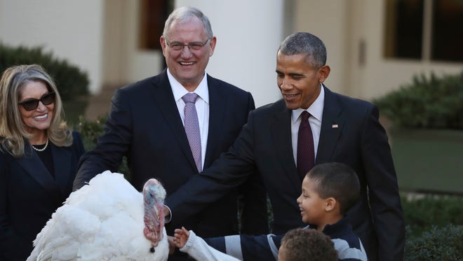 Obama, with his nephews Aaron Robinson, front, and Austin Robinson and National Turkey Federation Chairman John Reicks, pardons the National Thanksgiving Turkey, Tot, on Nov. 23, 2016, during a ceremony in the Rose Garden.