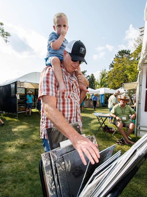 Greg Haynes of Oconomowoc shops for art with his two-year-old son Cullen at the 47th annual Oconomowoc Festival of the Arts in Fowler Park on Saturday, August 19, 2017.