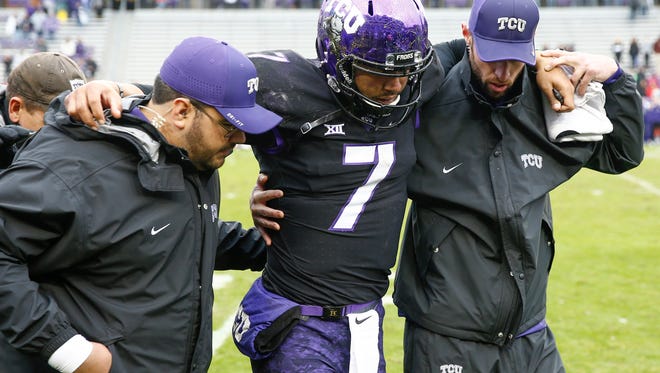 TCU quarterback Kenny Hill is helped off the field after an injury during the final seconds against the Kansas State.