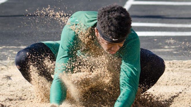 Wauwatosa West's Paris Howell gets a face full of sand while landing during the boys long jump. He won the event.