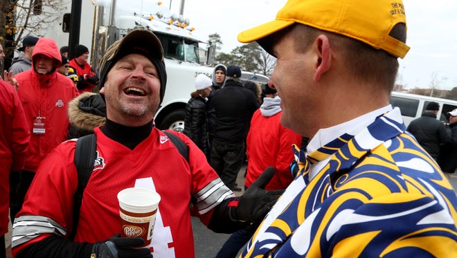 Ohio State fan Rick Hanna, 48 of Lancaster, Ohio has fun with Michigan fan Todd Schultz, 46 of Lambertville, Michigan and his uniquely designed suit with the Michigan colors before the game between Michigan and Ohio State at Ohio Stadium in Columbus on Saturday, November 26, 2016.