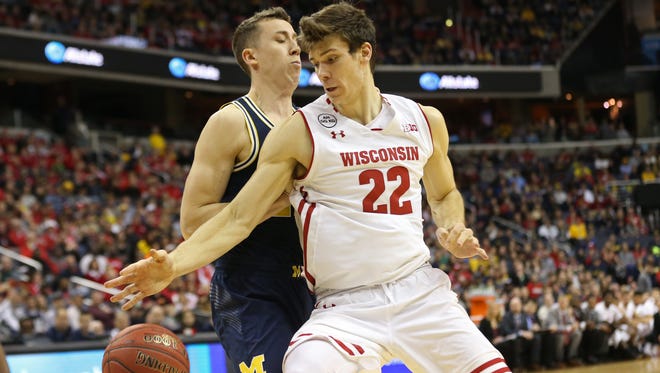 UW's Ethan Happ tries to work around Michigan's Duncan Robinson during the Big Ten tournament title game Sunday.