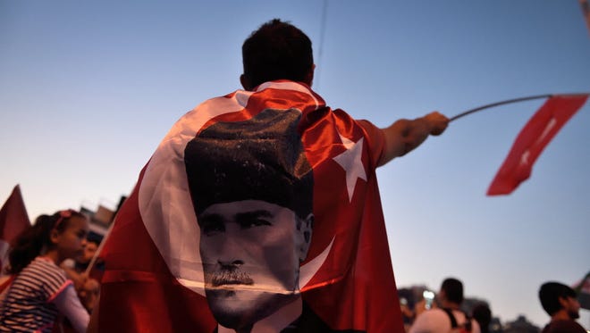 A boy is wrapped in a flag of the founder of modern Turkey Mustafa Kemal Ataturk on Taksim square in Istanbul on July 17.