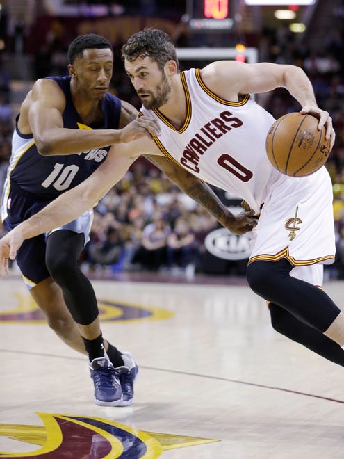 Cleveland Cavaliers' Kevin Love (0) drives past Memphis Grizzlies' Troy Williams (10) in the first half of an NBA basketball game, Tuesday, Dec. 13, 2016, in Cleveland. (AP Photo/Tony Dejak)