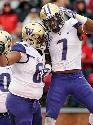 Washington linebacker Keishawn Bierria (7) and defensive lineman Damion Turpin (66) celebrate a sack against Washington State during the first half Friday in Pullman, Wash.