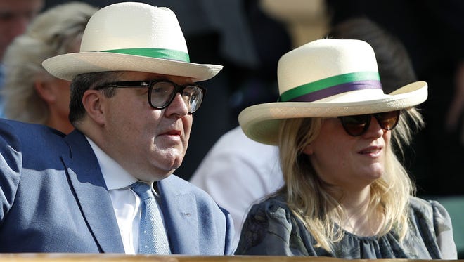 Britain's opposition Labour party seputy Tom Watson wears a sun hat as he watches Britain's Andy Murray.
