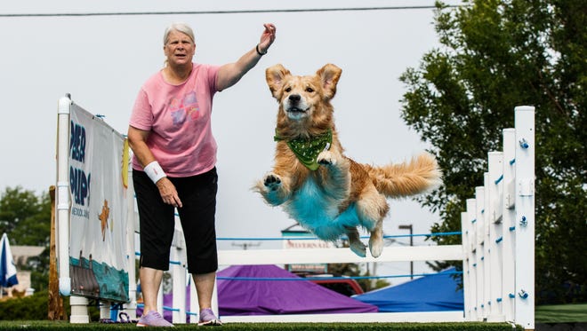 Diane Allard of Oak Creek looks on a her dog "Colton" takes flight for the Pier Pups canine dock jumping competition hosted by Petlicious Dog Bakery in Pewaukee on Sunday, August 20, 2017.