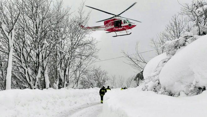 An Italian firefighter helicopter flies during rescue operations in the area where a hotel was hit by an avalanche in Farindola, Italy, Jan 19, 2017.