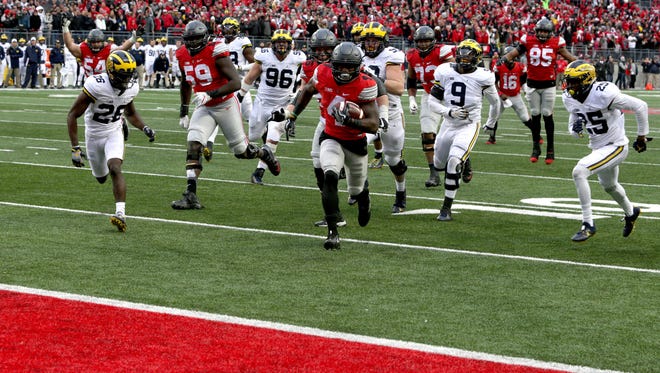Ohio State's Curtis Samuel runs into the end zone in the second overtime to give the Buckeyes a 30-27 win over Michigan at Ohio Stadium on Saturday, Nov. 26, 2016. Michigan's Jordan Lewis, left, and Dymonte Thomas, right, pursue Samuel.