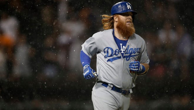 Los Angeles Dodgers 3rd baseman Justin Turner (10) jogs to first base during a rain storm in the game against the Chicago White Sox at Guaranteed Rate Field.