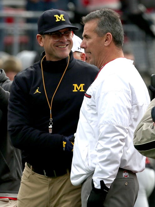 Michigan head coach Jim Harbaugh, left, and Ohio State head coach Urban Meyer shake hands before their teams battle it out at Ohio Stadium in Columbus, Ohio on Saturday, Nov. 26, 2016.