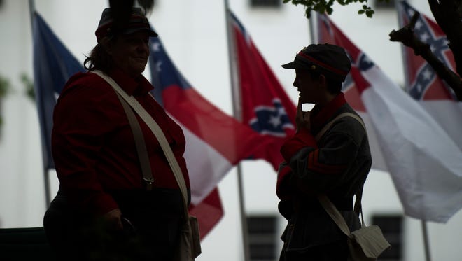 People dressed in Confederate Army clothing stand outside the Alabama Capitol building during a rally around the Confederate Monument on Confederate Memorial Day, Monday, April 24, 2017, in Montgomery, Ala.