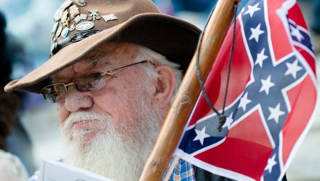 John Johnson looks on while holding a confederate flag during a Confederate Memorial Day service outside the Alabama Capitol on Monday, April 24, 2017, in Montgomery, Ala.