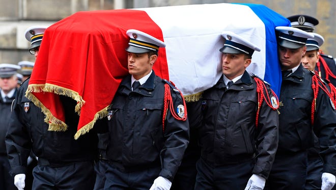 French police officers carry the flag-draped casket during a ceremony honouring the policeman killed by a jihadist in an attack on the Champs Elysees, on April 25, 2017 at the Paris prefecture building.