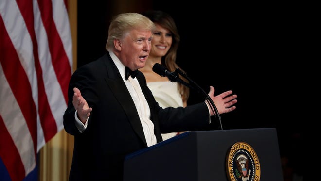 President Donald Trump speaks as his wife First Lady Melania Trump looks on during A Salute To Our Armed Services Inaugural Ball at the National Building Museum in Washington.