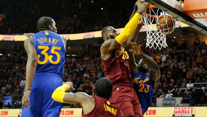 Cleveland Cavaliers forward LeBron James dunks on Golden State Warriors forward Draymond Green at Quicken Loans Arena.
