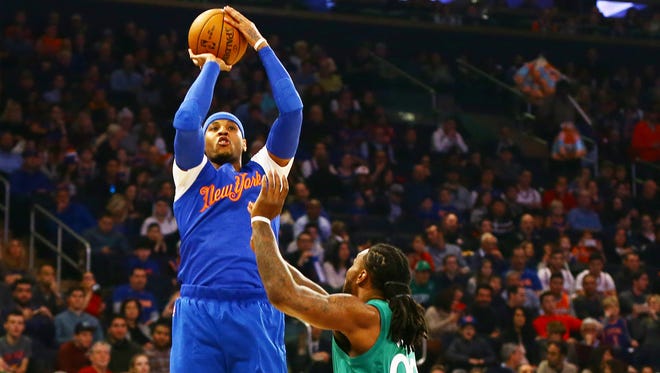 New York Knicks forward Carmelo Anthony (7) takes a shot while being defended by Boston Celtics forward Jae Crowder (99) during the first half at Madison Square Garden.