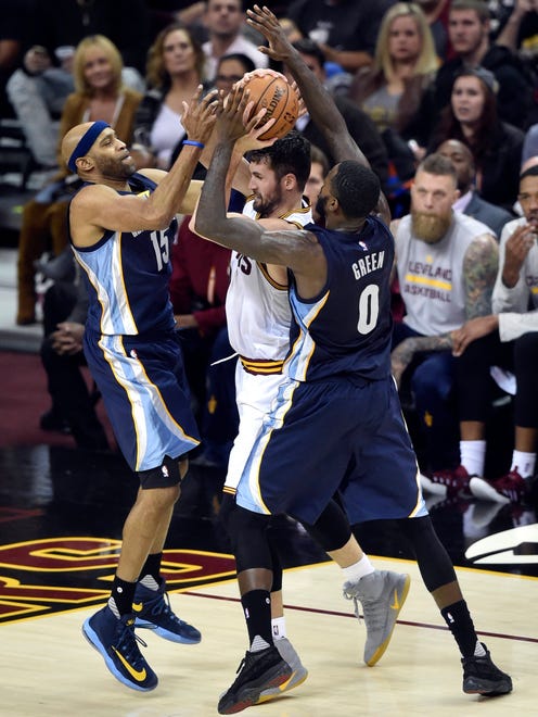 Memphis Grizzlies guard Vince Carter (15) and forward JaMychal Green (0) defend Cleveland Cavaliers forward Kevin Love (0) Tuesday at Quicken Loans Arena.