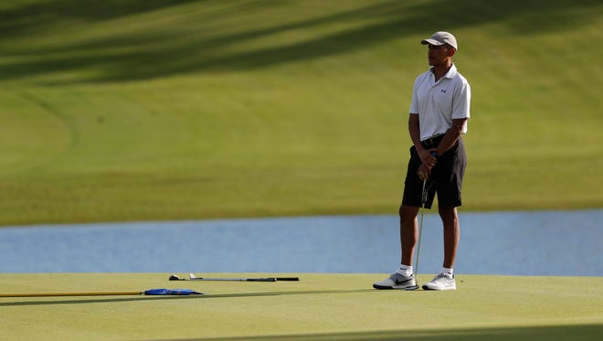 Obama pauses as he golfs on the 18th green at Kapolei Golf Club, in Kapolei, Hawaii, on Dec. 21, 2016.
