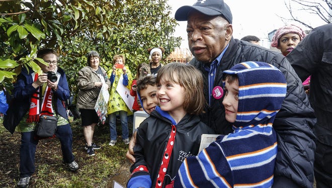 U.S. Rep. John Lewis poses for a photo with three children at the Women's March on Saturday, in Atlanta. The march drew thousands of attendees, including, U.S. Rep. John Lewis, who had been at odds with president Donald Trump leading up to the inauguration. Lewis told The AP, "We've made progress, but there are forces in America that want to take us back to another time and another place."