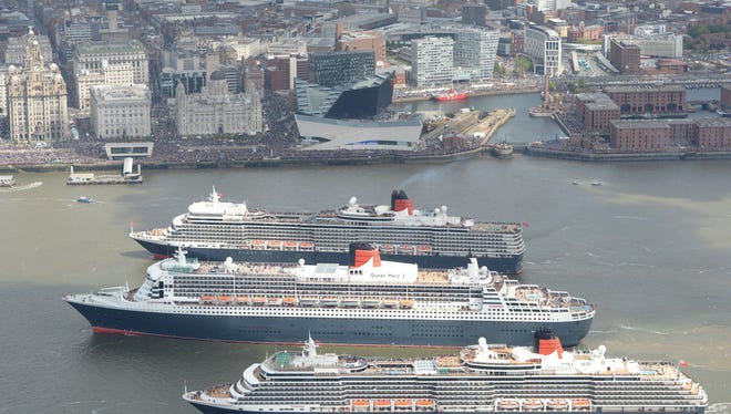 Queen Mary 2, Queen Victoria and Queen Elizabeth meet in the Mersey, Liverpool for a gathering in front of the Three Graces and thousands of people on the riverside.
