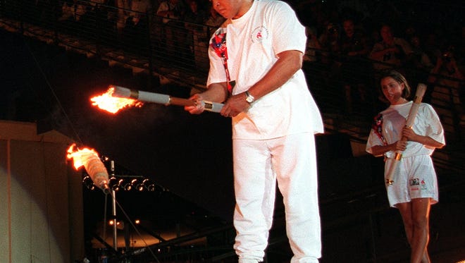 Muhammad Ali lights the Olympic flame at the 1996 opening ceremony.