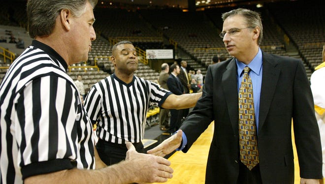 Southern Misissippi Coach Larry Eustachy gets a warm greeting from officials Steve Skiles, left and Sam Banks before his team took on UNC-Greensboro in Iowa City on Friday, Dec. 3, 2004.