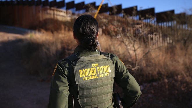 U.S. Border Patrol agent Nicole Ballistrea watches over the United States-Mexico border fence on Dec. 9, 2014 in Nogales, Arizona.