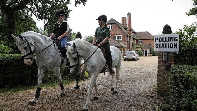 Jacqui Vaughan, left, and Sophie Allison, on horses Splash and Sharna, ride out of the driveway of a private residence used as a polling station, near Reading, west of London, as Britain holds a referendum to vote on whether to remain in or to leave the European Union. The rural house where Allison runs her livery business has been a polling station for local residents for more than 40 years.
