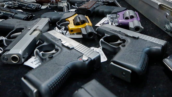 Handguns are displayed on a vendor's table at an annual gun show in Albany, N.Y. In an Associated Press/USA TODAY Network investigation into accidental shootings involving children from Jan. 1, 2014, to June 30, 2016, more than 320 minors and more than 30 adults were fatally shot.