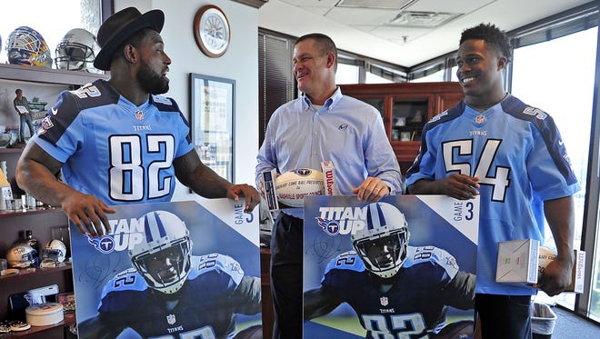 Titans players Delanie Walker, left, and Avery Williamson, right, deliver Titans season tickets to Scott Ramseyon July 29, 2015.