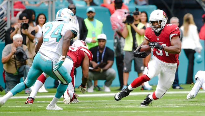 Arizona Cardinals running back David Johnson (31) carries the ball as Miami Dolphins strong safety Isa Abdul-Quddus (24) makes the tackle during the first half at Hard Rock Stadium.