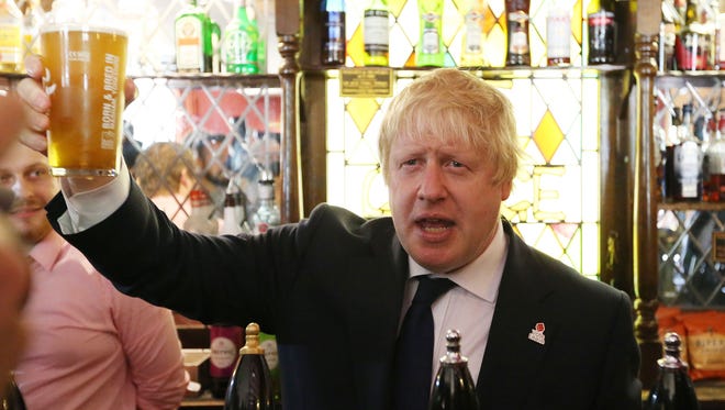 Former London Mayor, and "Vote Leave" campaigner Boris Johnson is pictured with a pint of beer ahead of meeting with members of the public and supporters in Piercebridge, England, on June 22, 2016, as he continued to campaign for a Brexit.