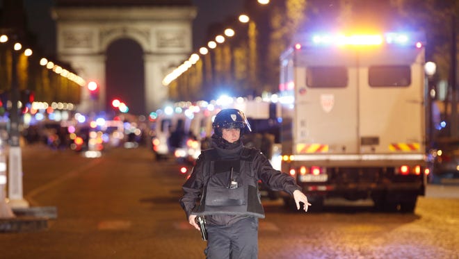 A police officer stands guard after a fatal shooting in which a police officer was killed along with an attacker on the Champs Elysees in Paris, France on April 20, 2017. French media are reporting that two police officers were shot Thursday on the famed shopping boulevard. Many police vehicles can be seen on the avenue that passes many of the city's most iconic landmarks.