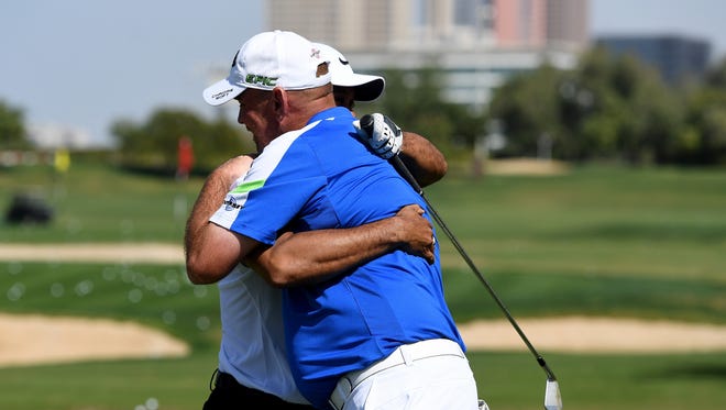 Tiger Woods and Thomas Bjorn of Denmark share a hug on the driving range prior to the Omega Dubai Desert Classic at Emirates Golf Club on Jan. 31.
