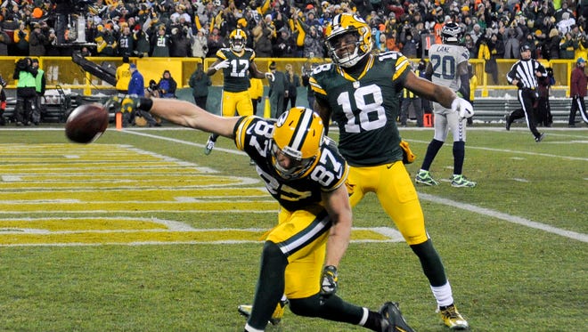 Packers wide receiver Jordy Nelson (87) spikes the football with wide receiver Randall Cobb (18) after scoring a touchdown.