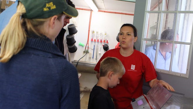 Ashley Schlender and her son Trent, 9,  explain a calf feeder to 11 Nuffield scholars visiting Never Rest Dairy in Jefferson County as part of a one day, three-county tour in Wisconsin on June 19. It's the first time the group has visited Wisconsin during their world-wide tour.