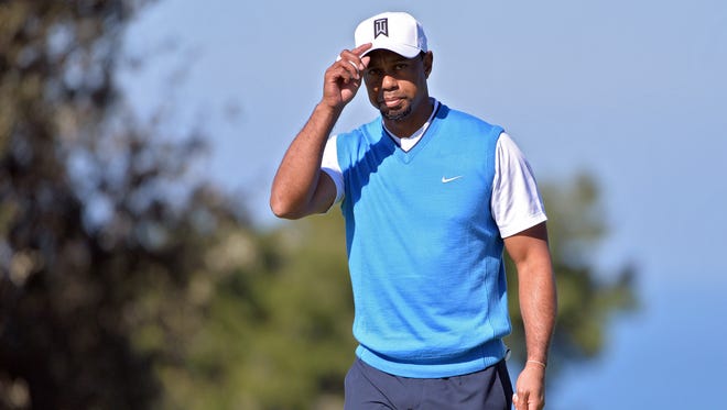 Tiger Woods acknowledges the crowd following a putt on the 2nd hole during the first round of the Farmers Insurance Open golf tournament at Torrey Pines Municipal Golf Course.
